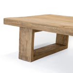 Close-up view of a rectangular wood coffee table with a sturdy base